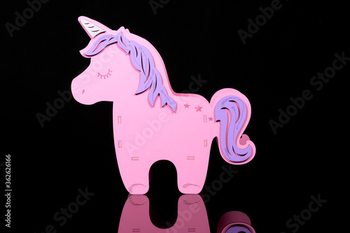 pink toy unicorn of a child on a dark background photo