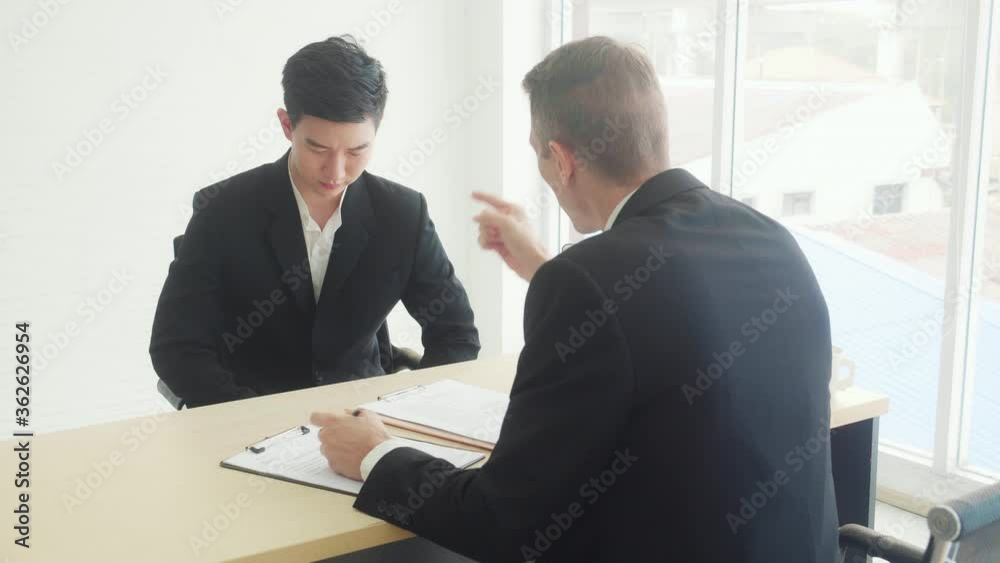 Young executive manager reading report financial and reprimand employee at the office, businessman stress and failure for mistake, problem in work, man and complain with angry, business concept. Young executive manager reading report financial and reprimand employee at the office, businessman stress and failure for mistake, problem in work, man and complain with angry, business concept.