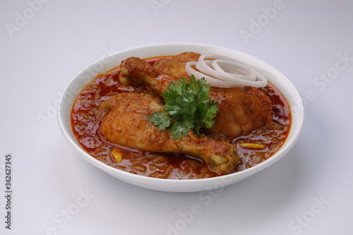 Chicken curry or masala,arranged in awhite bowl with white background