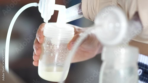 Mom use electric breast pump feeding for her baby.
