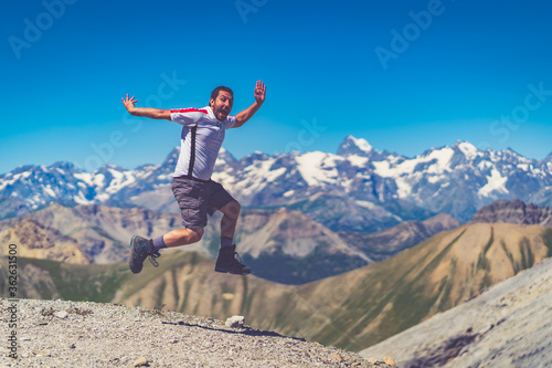 Happy Man traveler jumping with backpack Travel Lifestyle adventure concept active summer vacations outdoor in alps mountains success and fun euphoria emotions