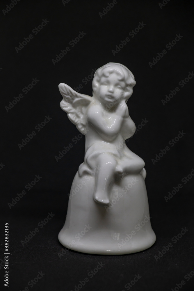 white angel doll with a cute face made of clay on a black background