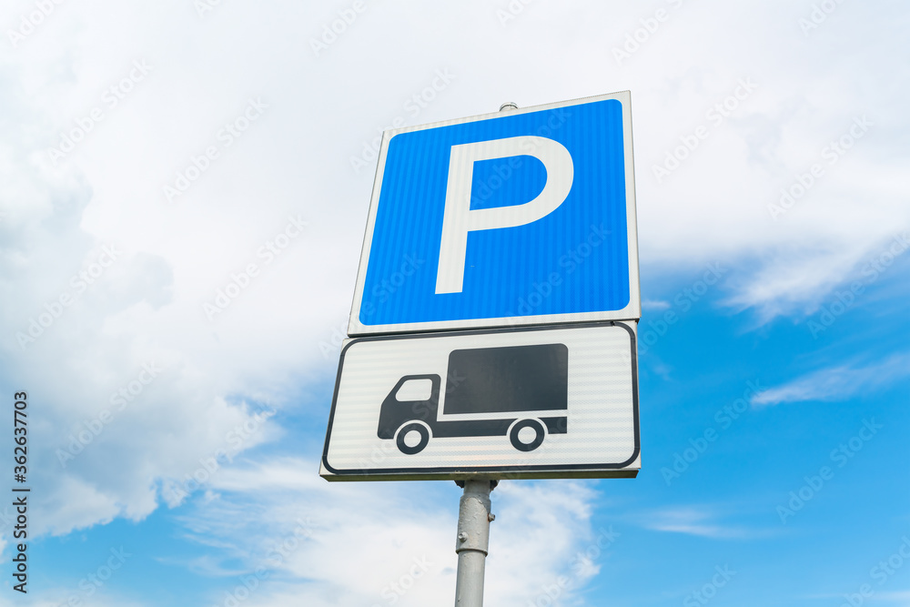 Lorry parking sign against the blue sky. Blue parking sign. Black truck on white plate. High quality photo Lorry parking sign against the blue sky. Blue parking sign. Black truck on white plate. High quality photo