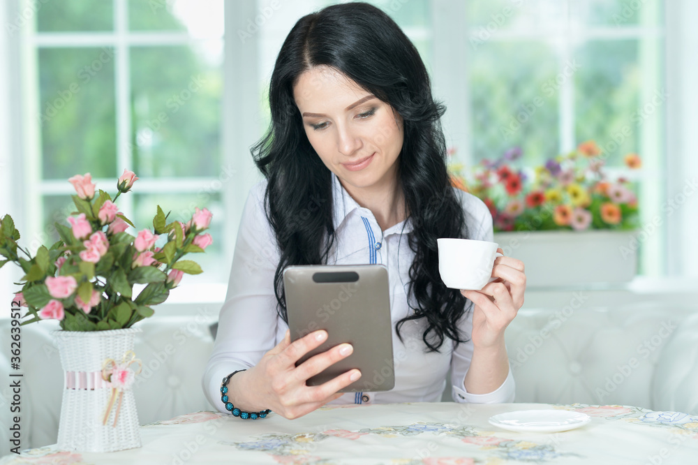 Close up portrait of beautiful blonde young woman using tablet