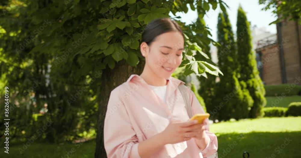 Happy asian student woman using mobile phone smartphone outdoors in city street. Happy asian student woman using mobile phone smartphone outdoors in city street.