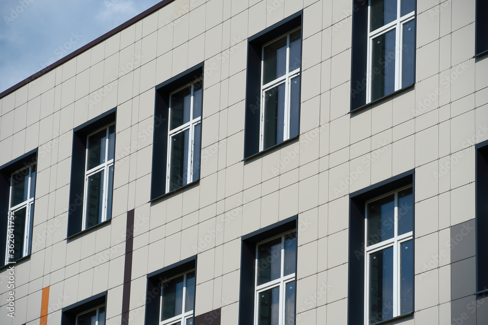 facade of a modern building on a bright Sunny day, siding and Windows, beautiful exterior of the new building