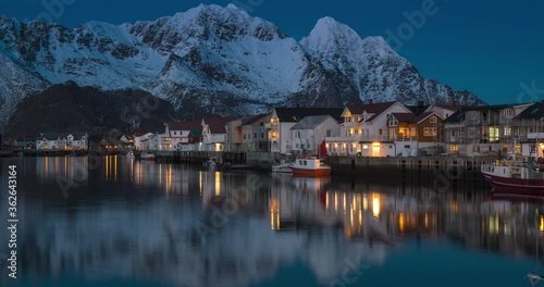 4K-10BIT-YUV422 day to night timelapse of Henningsvaer fishing village with snow mountain and fishing cabins and boats, Lofoten island, Norway