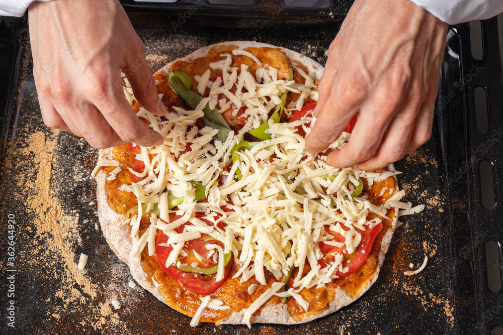 Pizza maker prepares vegetarian pizza, puts out the ingredients