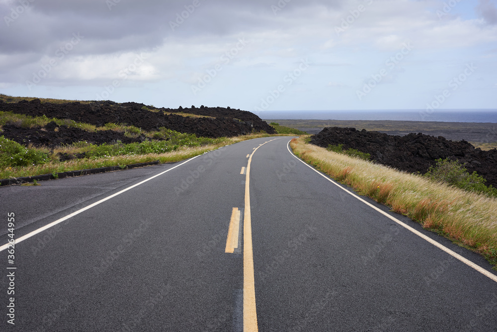 Chain of Craters Road in Hawaii Volcanoes Nation Park with the Pacific Ocean in the near distance as the sky gradually clears up. Chain of Craters Road in Hawaii Volcanoes Nation Park with the Pacific Ocean in the near distance as the sky gradually clears up.