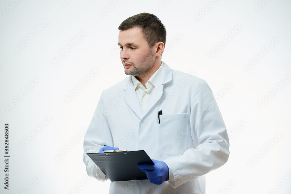 A serious male caucasian doctor in a white lab coat and blue disposable medical gloves is thinking about a patient diagnosis. A scientist is isolated over white background. A serious male caucasian doctor in a white lab coat and blue disposable medical gloves is thinking about a patient diagnosis. A scientist is isolated over white background.