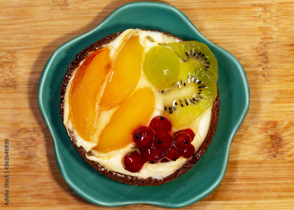 Handmade cake with fruits and berries. Kiwi, red berry, grape, peach. 