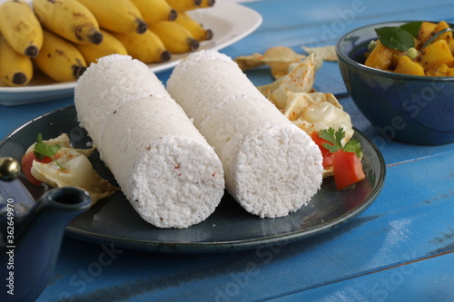 PUTTU or WHITE RICE PITTU ,Kerala special breakfast items made using rice flour which is very healthy and arranged in traditional way with  blue background photo