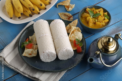 PUTTU or WHITE RICE PITTU ,Kerala special breakfast items made using rice flour which is very healthy and arranged in traditional way with  blue background photo