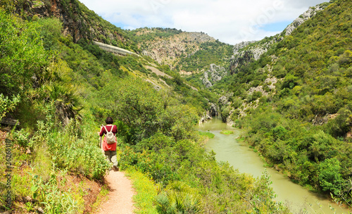 Mujer caminando en el río Guadiaro cerca del Cañón de las Buitreras -Canon de las Buitreras-, famoso desfiladero ubicado en el Parque Natural de los Alcornocales, provincia de Málaga, Andalucía, Españ photo