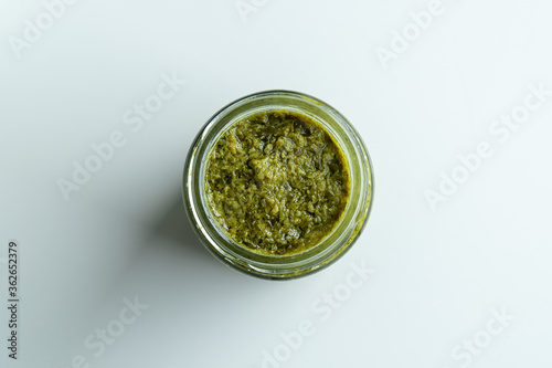 Background homemade cooking recipe green pesto pasta organic healthy food sauce in glass jar made from fresh basil leaf herb parmesan cheese nuts for healthy vegetarian vegan meal