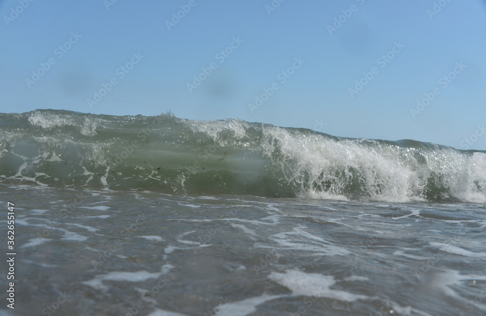 during the day the sea waves and splashes of small drops fall on the shore during the day the sea waves and splashes of small drops fall on the shore