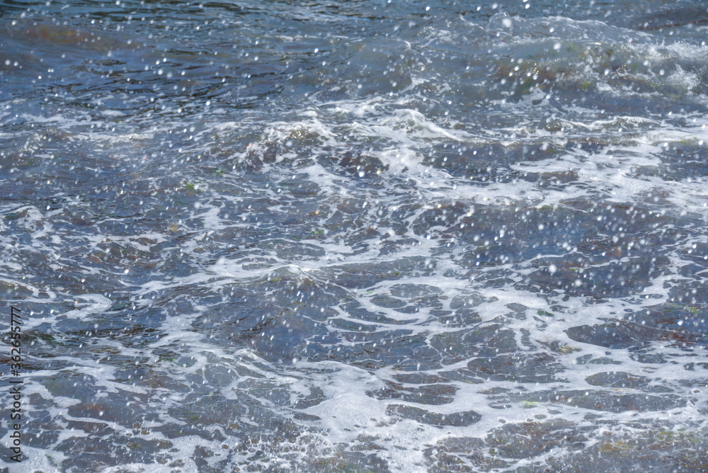 during the day the sea waves and splashes of small drops fall on the shore during the day the sea waves and splashes of small drops fall on the shore