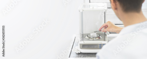 Fotografi A chemist in a white coat is weighing white powder