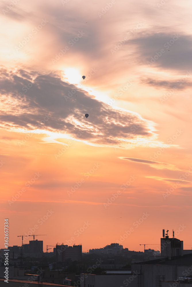 Two balloons on a background of pink sunset and clouds