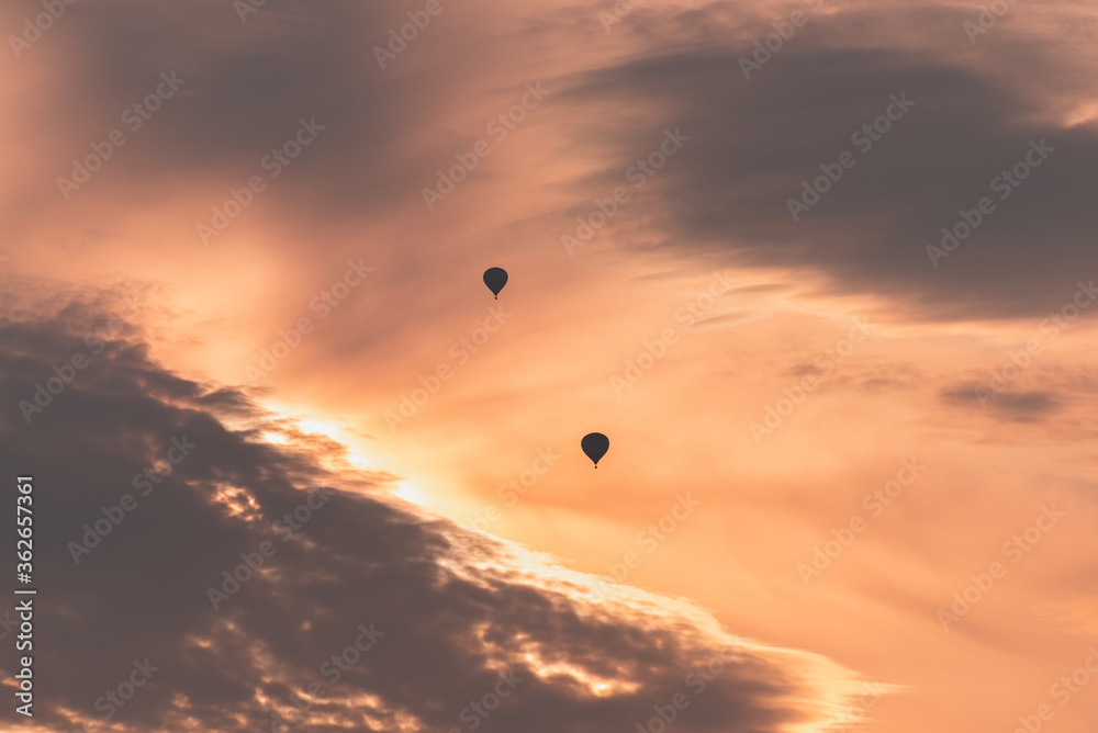 Two balloons on a background of pink sunset and clouds