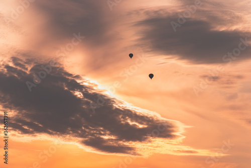 Two balloons on a background of pink sunset and clouds