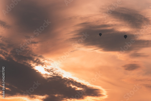 Obraz na płótnie Two balloons on a background of pink sunset and clouds w salonie