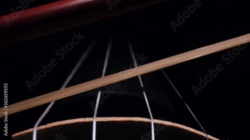 Close-up of the movement of the bow on the strings of a violin