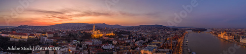 Panoramic aerial drone shot of lighted Matthias Churh Buda castle on Buda Hill by Danube in Budapest sunset