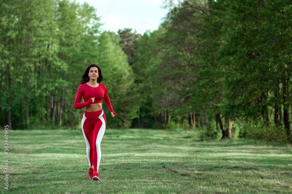 A girl in a tracksuit sits in a lotus position, ega on a background of nature. The concept of a healthy lifestyle, cardio training, fresh air. Copy space. A girl in a tracksuit sits in a lotus position, ega on a background of nature. The concept of a healthy lifestyle, cardio training, fresh air. Copy space.