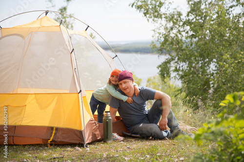 Happy family dad and child on camping trip relaxing inside tent. Staycations, hyper-local travel, family outing, getaway.