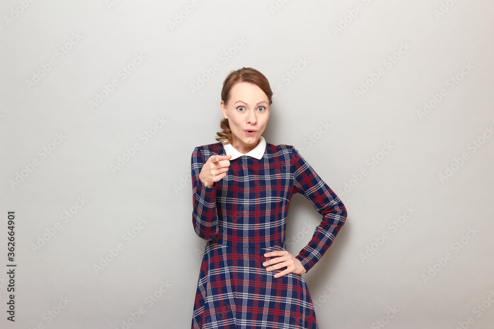 Portrait of amazed blond young woman pointing with index finger at you Portrait of amazed blond young woman pointing with index finger at you