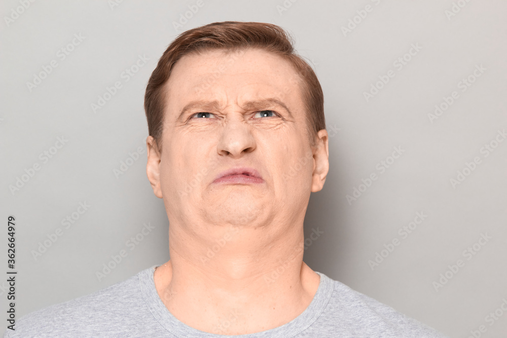 Portrait of funny man grimacing from disgust and squeamishness Portrait of funny man grimacing from disgust and squeamishness