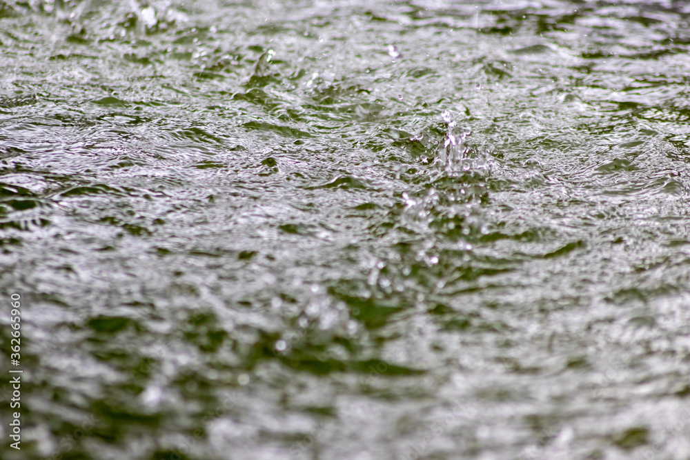 Raindrops falling to the floor in heavy rain day into a puddle on an splashy country road in spring offer a refreshing water shower for plants and trees after an absolute drought and meagerness Raindrops falling to the floor in heavy rain day into a puddle on an splashy country road in spring offer a refreshing water shower for plants and trees after an absolute drought and meagerness