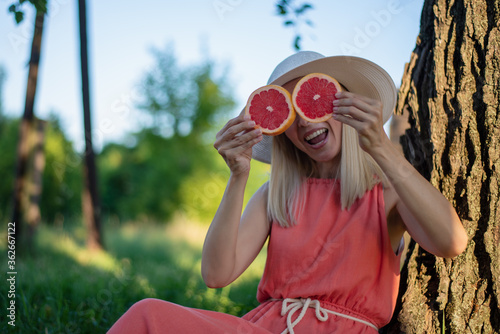 Funny girl holding two orange slices on eyes