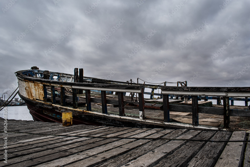 Fototapeta premium Old dilapidated fishing boat docked in a harbor