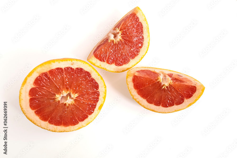 Ripe red whole and sliced grapefruit on white background. Minimal fruit concept. Ripe red whole and sliced grapefruit on white background. Minimal fruit concept.