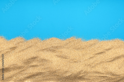 The sand isolated on blue background. Flat lay top view. Copy space.