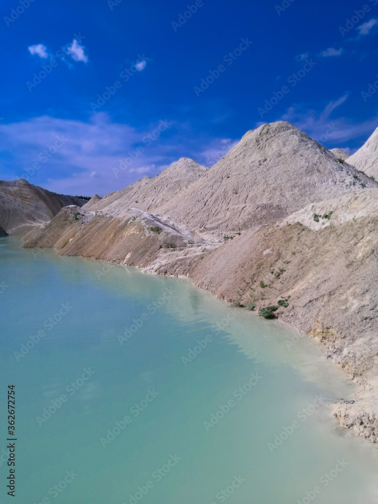 Beautiful summer landscape. Turquoise water between sand mountains in the desert.