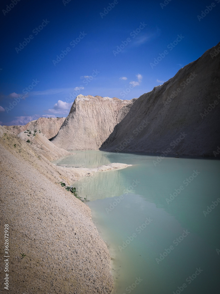 Beautiful summer landscape. Turquoise water between sand mountains in the desert.