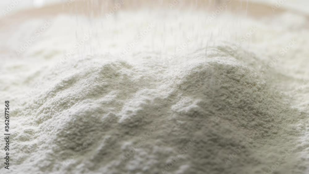 Close up shot of sieving white wheat flour trough a medium sized sieve in slow motion. Close up shot of sieving white wheat flour trough a medium sized sieve in slow motion.
