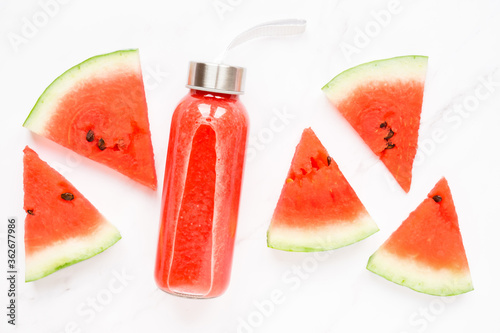 Fitness, healthy nutrition diet concept. Fresh cool watermelon juice in a glass jar and watermelon slices on a light background. Summer concept. top view flat lay
