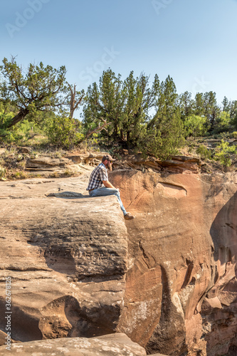 Man sitting on the edge of a cliff, Palo Duro Canyin State Park, Texas photo