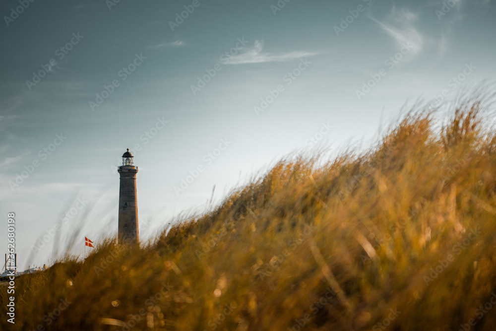 Beautiful summer beach view and the famous Skagen Gray Lighthouse at the top of denmark with colorful sunset light. Relax evening ocean walk. wonderful travel place in Europe and scandinavia. Skagen