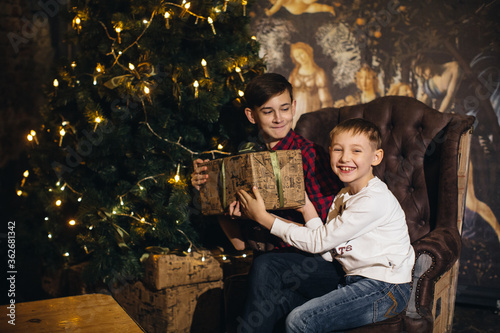 Two teenage boys, brothers in a new year or Christmas interior