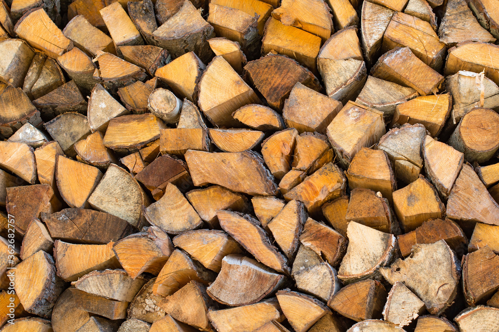Stack (woodpile) of firewood for rural energy resources. Dry chopped wood logs in a pile close up Stack (woodpile) of firewood for rural energy resources. Dry chopped wood logs in a pile close up
