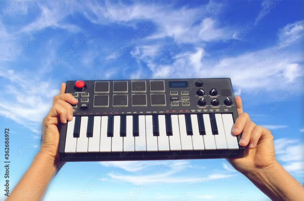 Hands holding music piano keyboard background sky concept