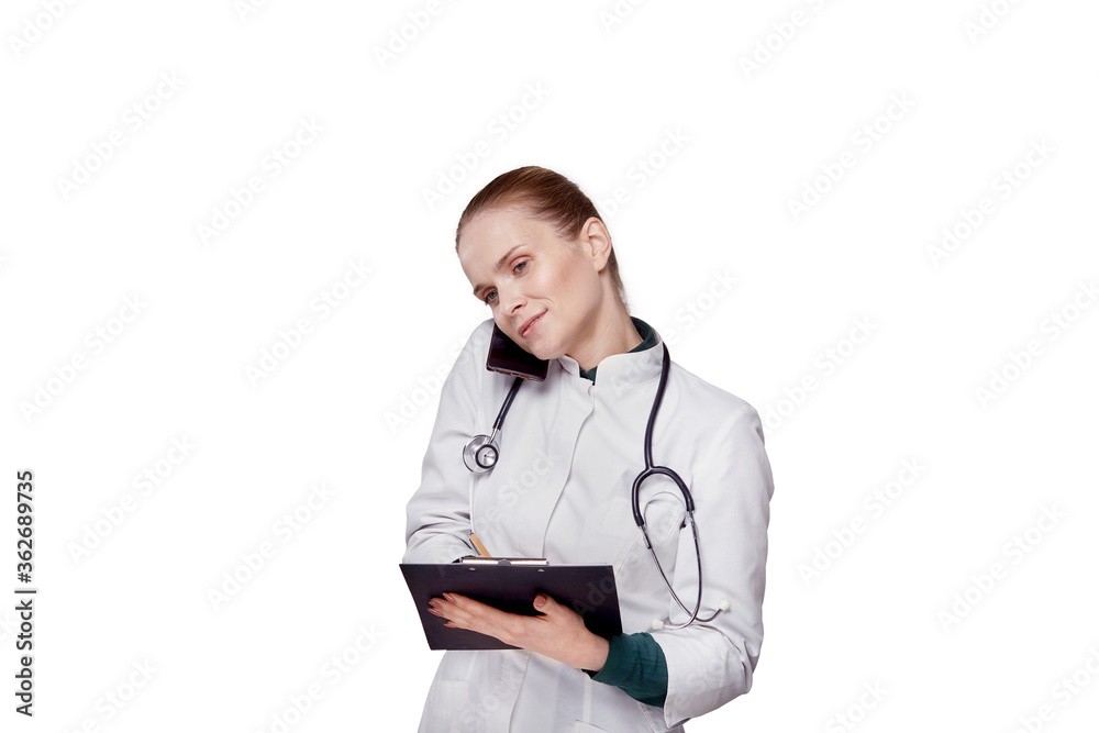 A female doctor is talking on a cell phone and recording information. A female doctor is talking on a cell phone and recording information.