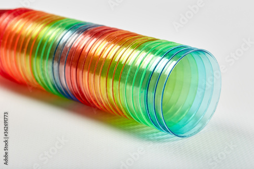 Many multi-colored rainbow colored plastic glasses are stacked together.