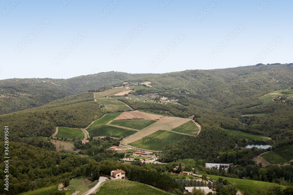 Beautiful scenery looking across Tuscany featuring vineyards, buildings, farms