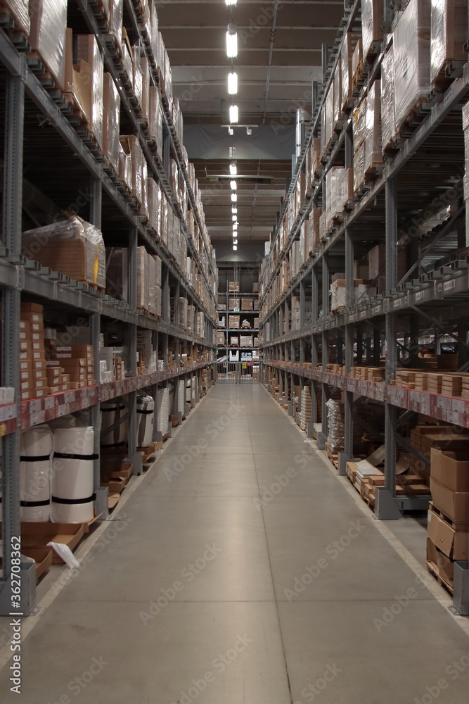 long hallway of a large warehouse with shelves up to the ceiling